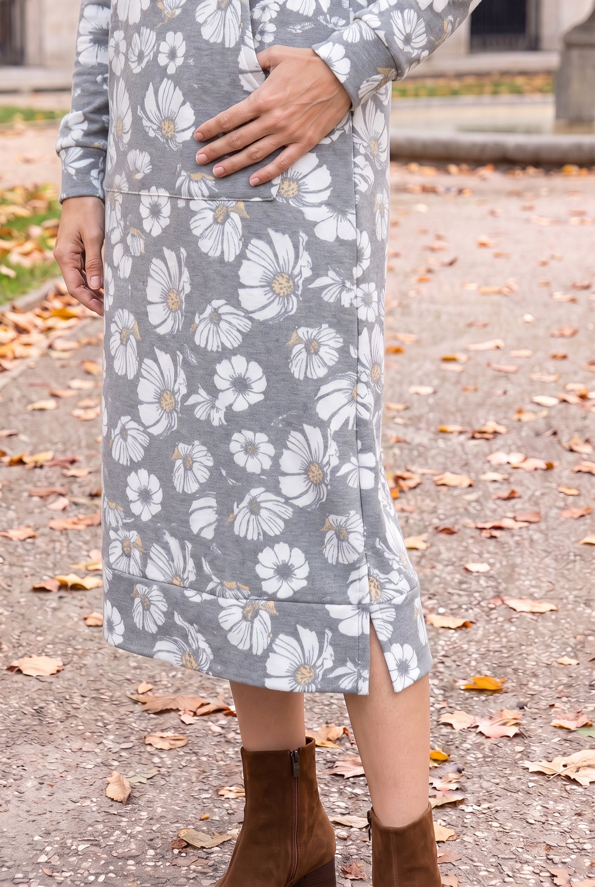 Nuggles® Hoodie Dress in Daisy Moon, close-up of the banded hem and side slit above brown ankle boots