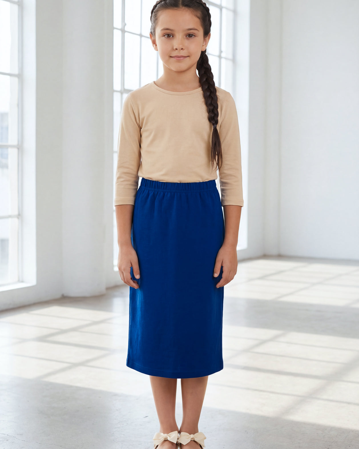 Model wearing the Nuggles® Girls' Classic Midi Skirt in Dark Royal Blue
