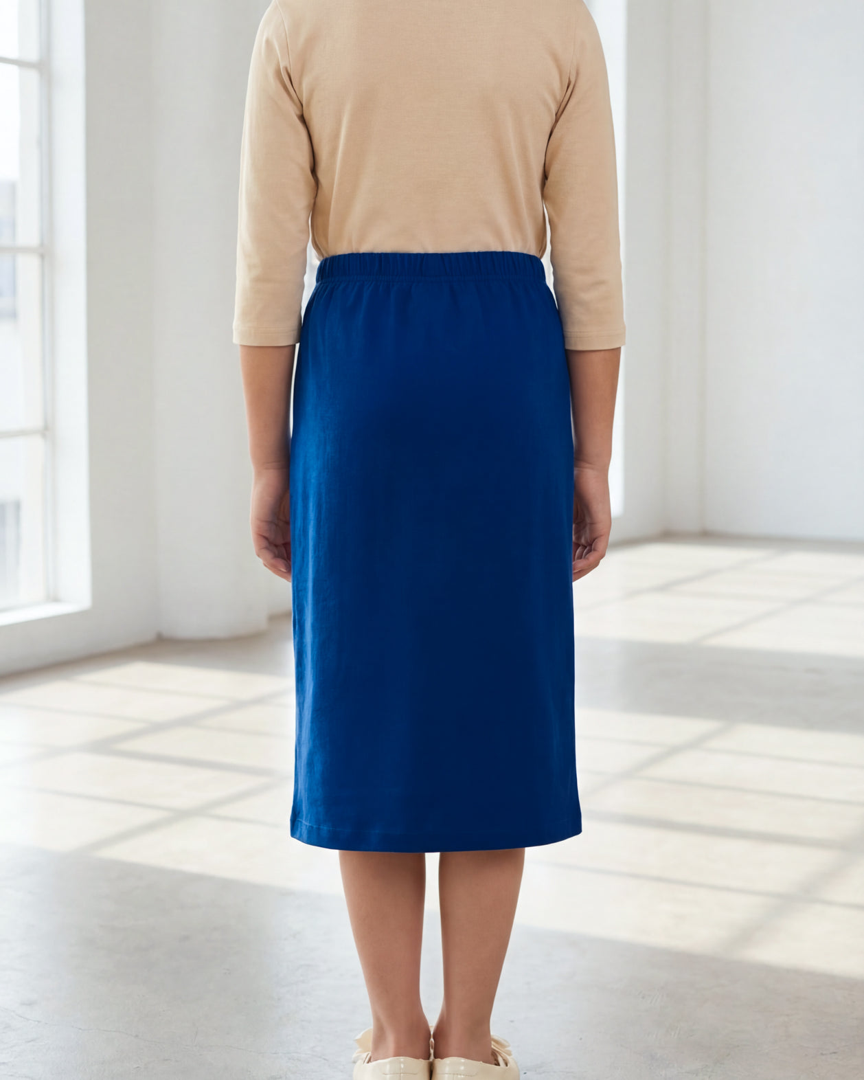 Model wearing the Nuggles® Girls' Classic Midi Skirt in Dark Royal Blue