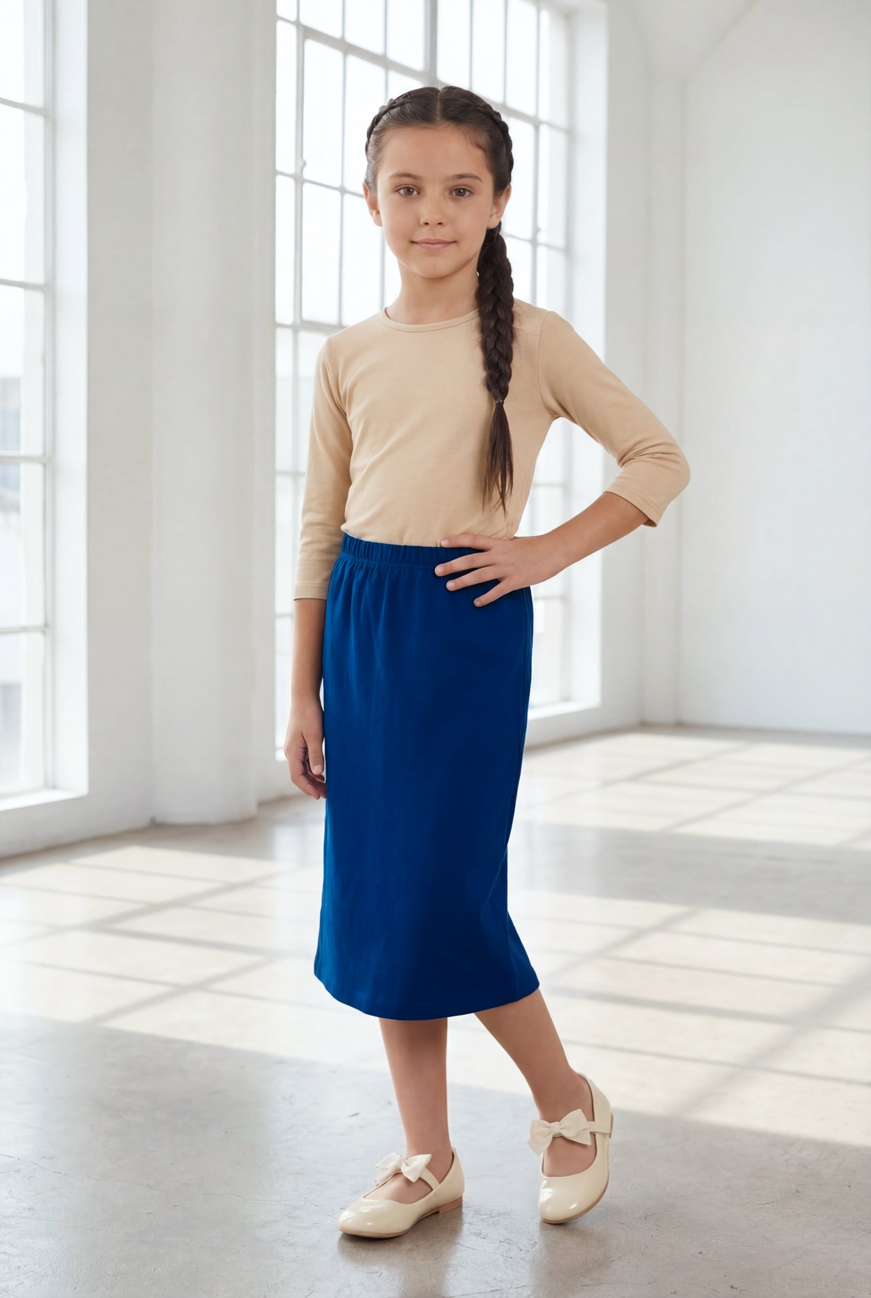 Model wearing the Nuggles® Girls' Classic Midi Skirt in Dark Royal Blue