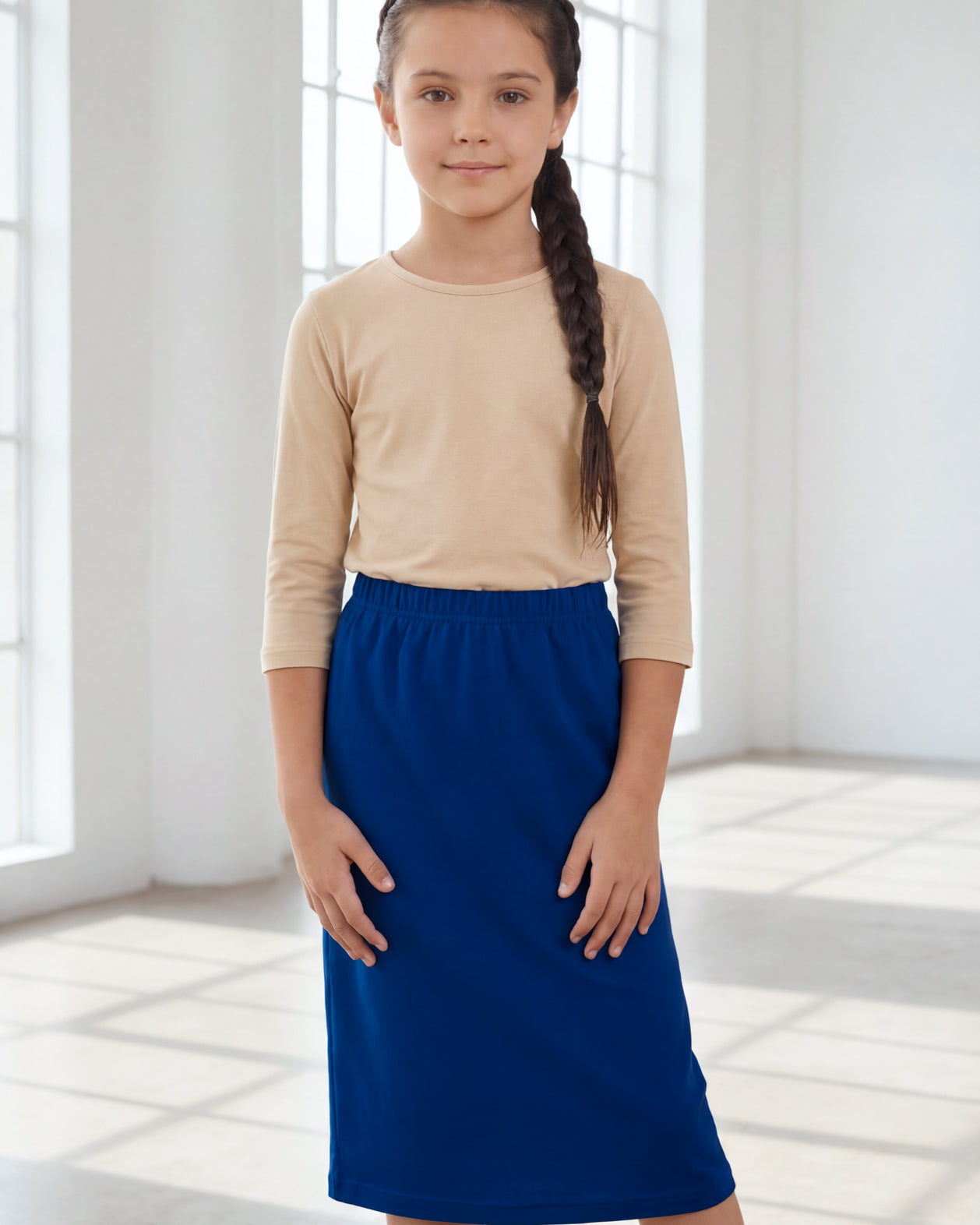 Model wearing the Nuggles® Girls' Classic Midi Skirt in Dark Royal Blue