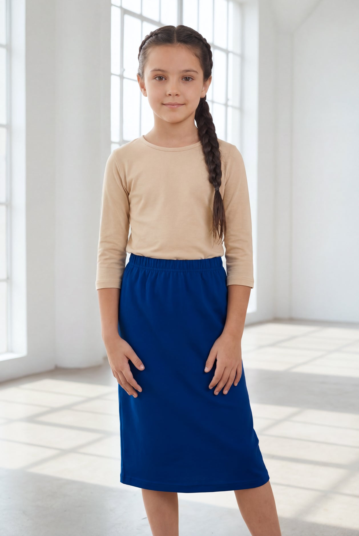 Model wearing the Nuggles® Girls' Classic Midi Skirt in Dark Royal Blue