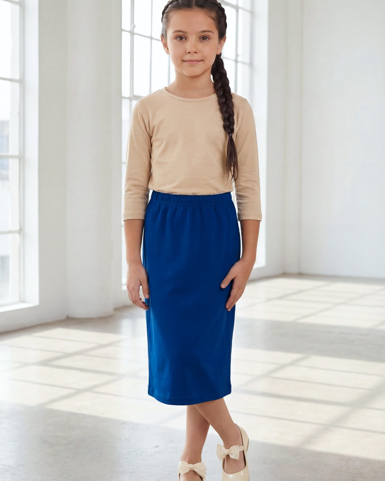 Model wearing the Nuggles® Girls' Classic Midi Skirt in Dark Royal Blue