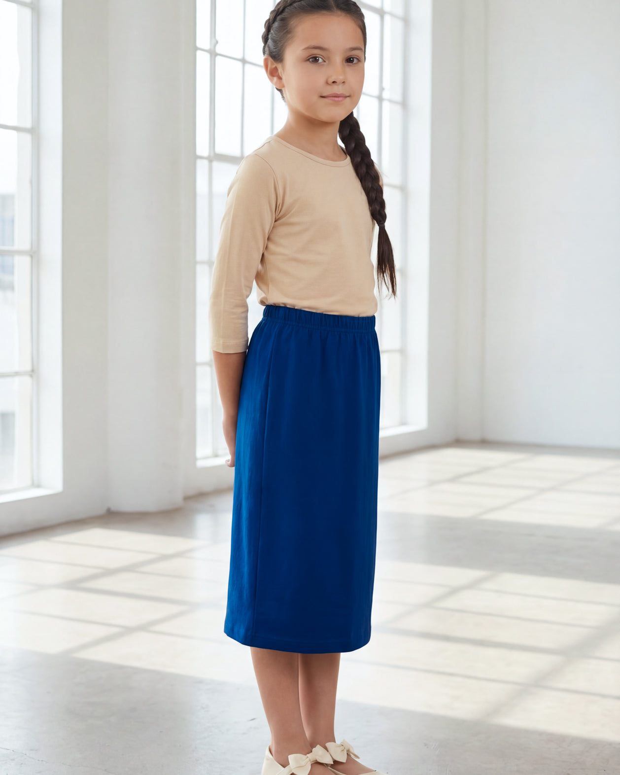 Model wearing the Nuggles® Girls' Classic Midi Skirt in Dark Royal Blue