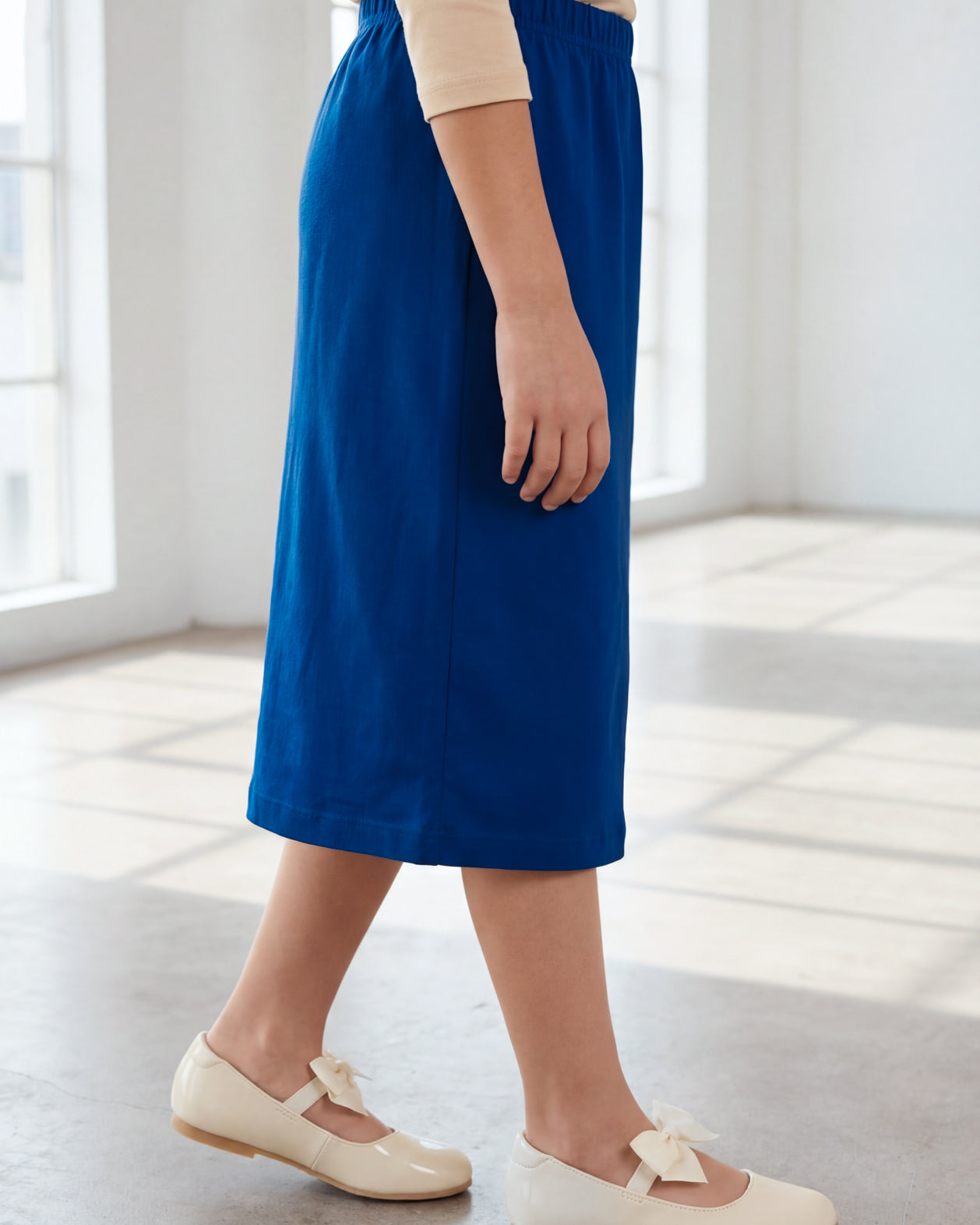 Model wearing the Nuggles® Girls' Classic Midi Skirt in Dark Royal Blue