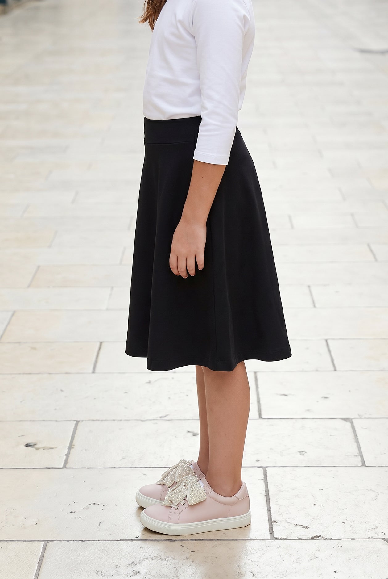 Model wearing Nuggles® Girl's Athleisure Skirt in Black