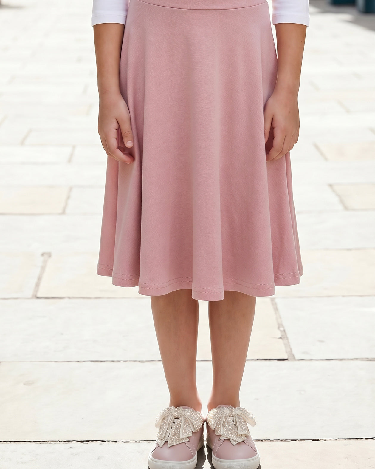Model wearing Nuggles® Girl's Athleisure Skirt in Dusty Pink