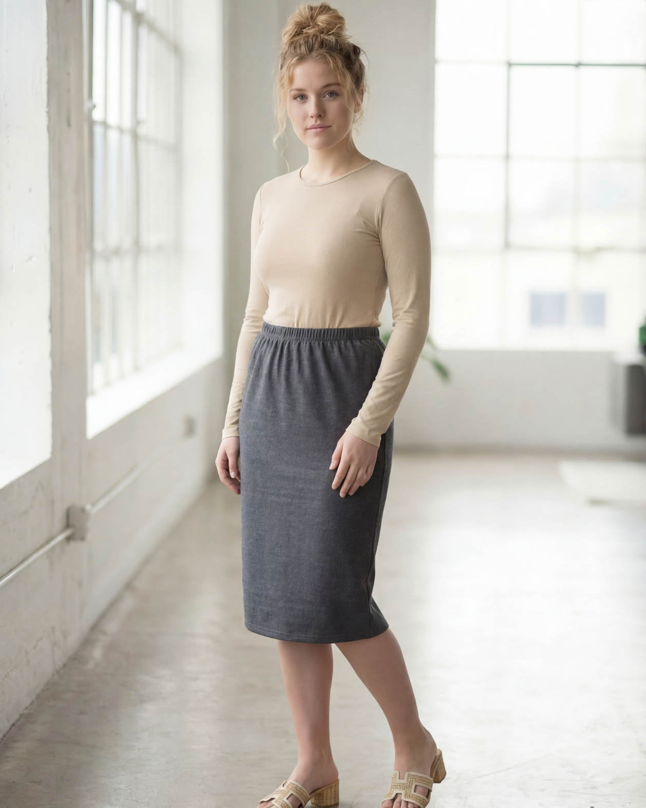 Women wearing a heather gray classic 27" midi length skirt with a beige shirt in a sunlight loft.