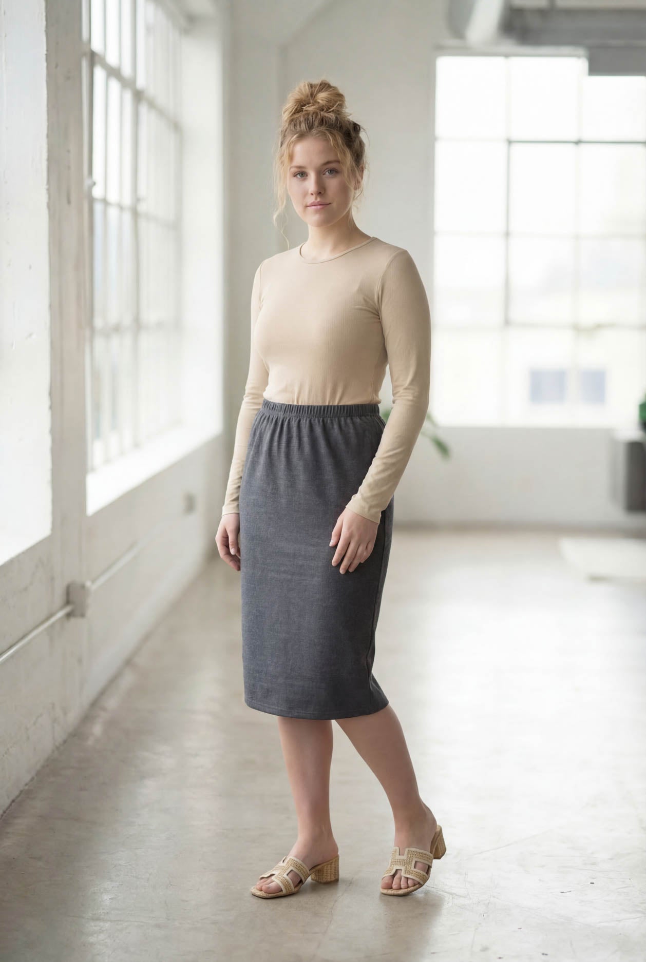 Women wearing a heather gray classic 27" midi length skirt with a beige shirt in a sunlight loft.