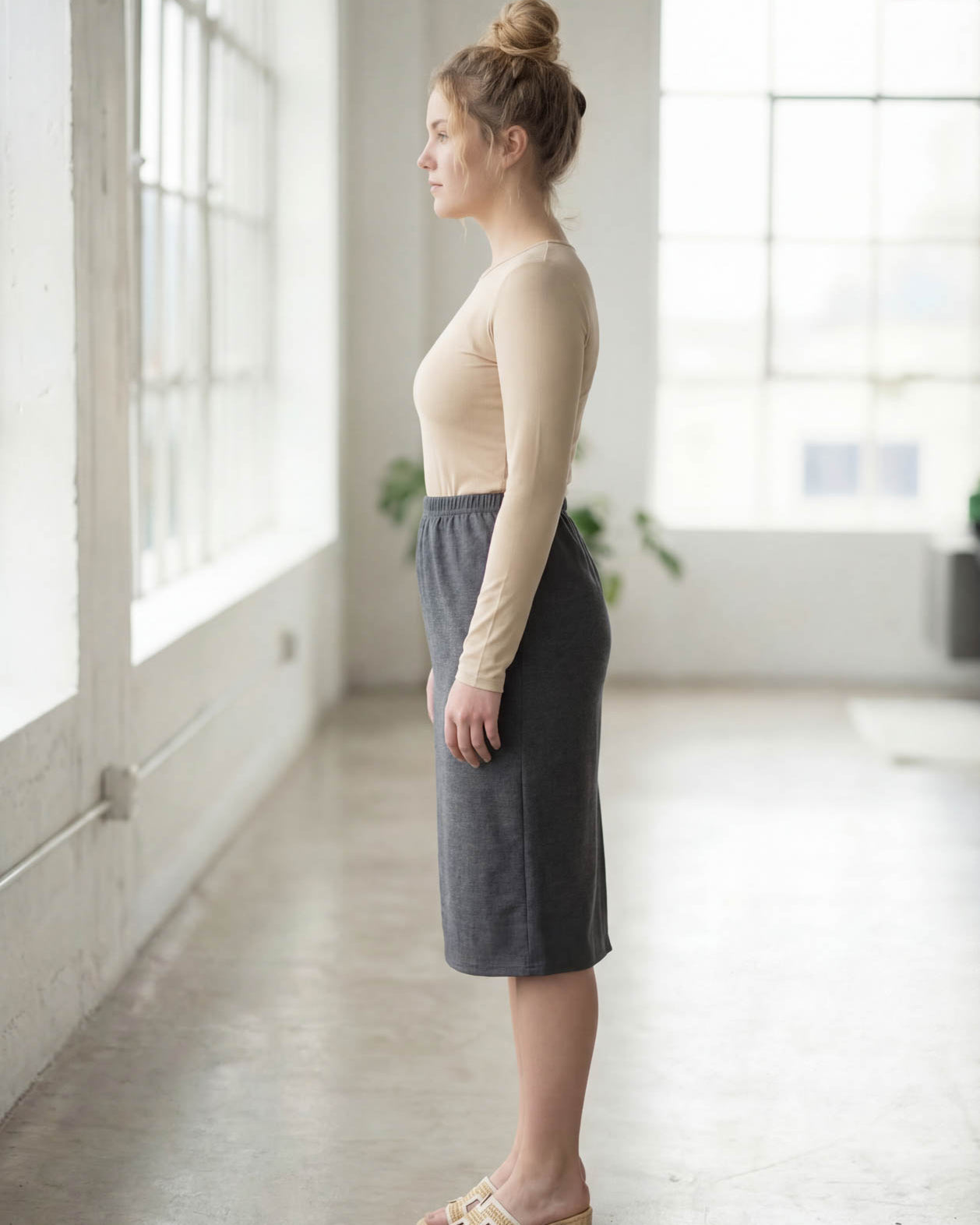 Women wearing a heather gray classic 27" midi length skirt with a beige shirt in a sunlight loft.