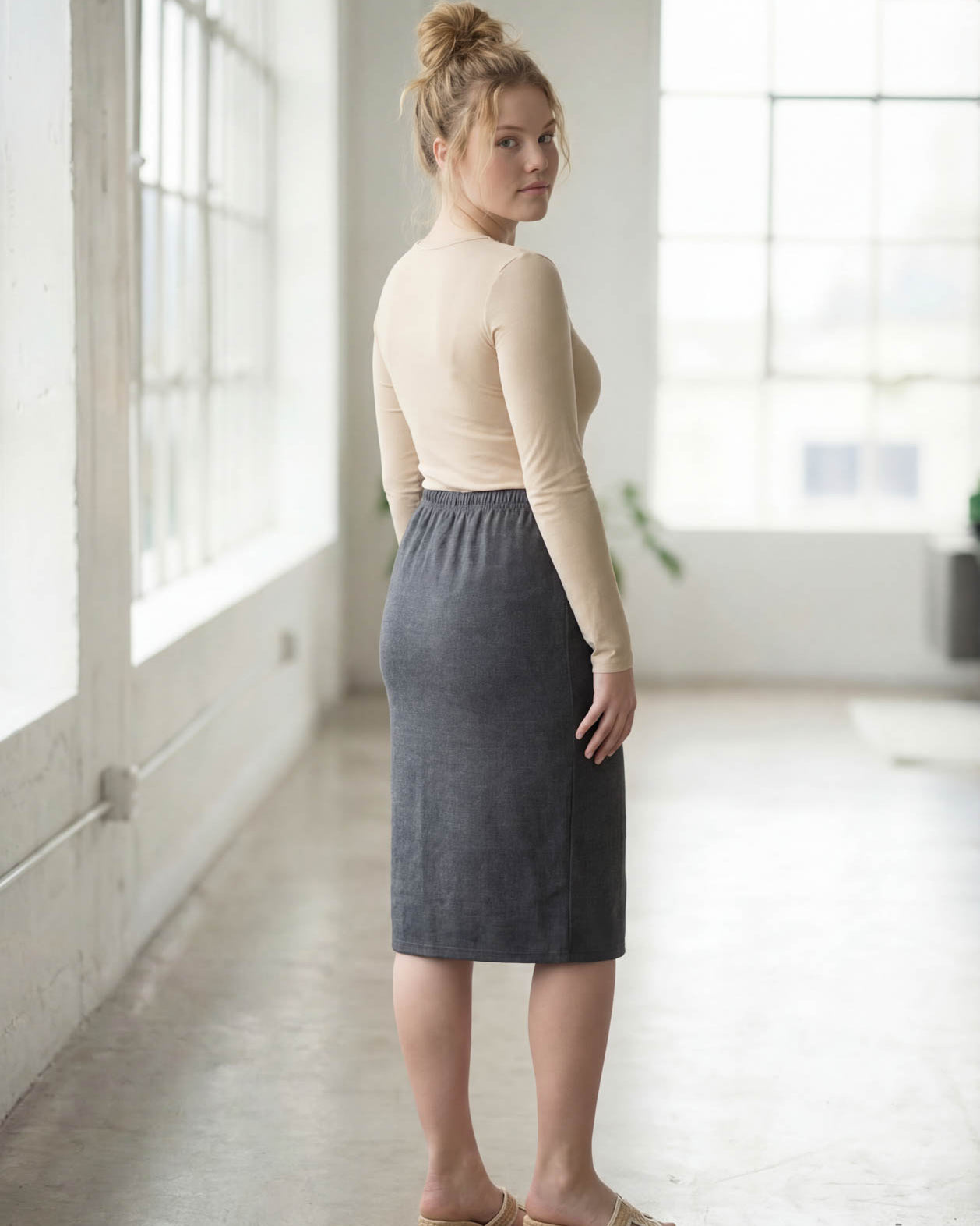Women wearing a heather gray classic 27" midi length skirt with a beige shirt in a sunlight loft.