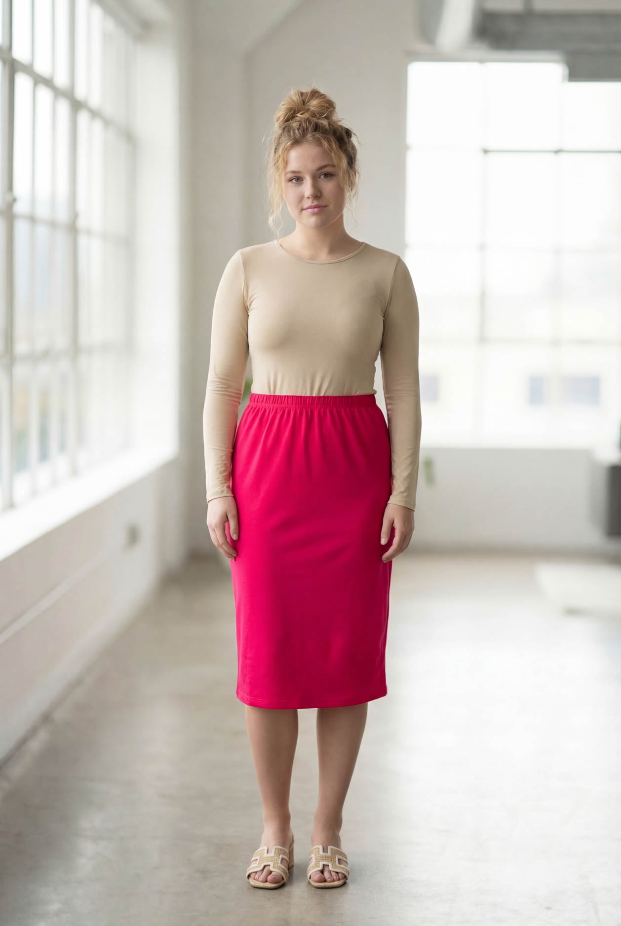 Women wearing a brick hot pink classic 27" midi length skirt with a beige shirt in a sunlight loft.