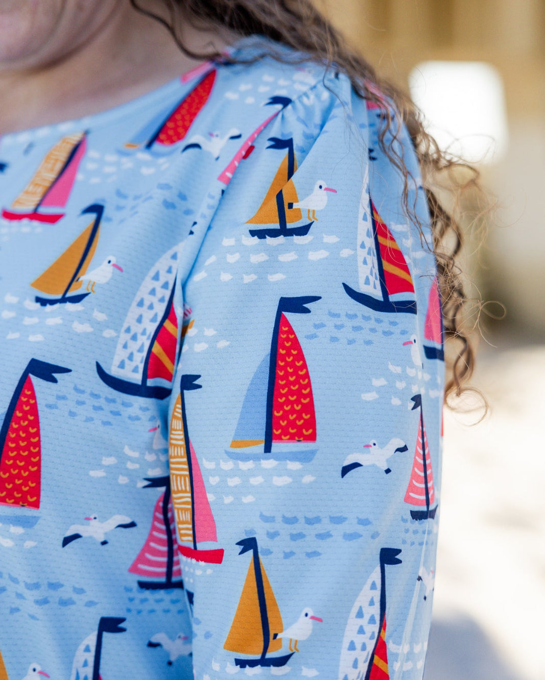 Model wearing Nuggles® Nola Sport Swim Dress in Harbor Sailboats