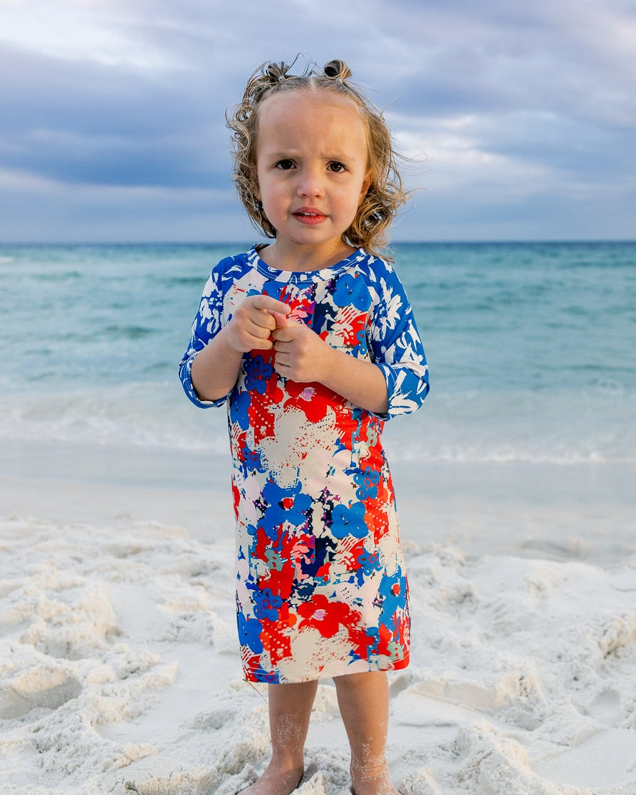 Model wearing Nuggles® Girls' Sport Swim Dress in Firecracker Garden