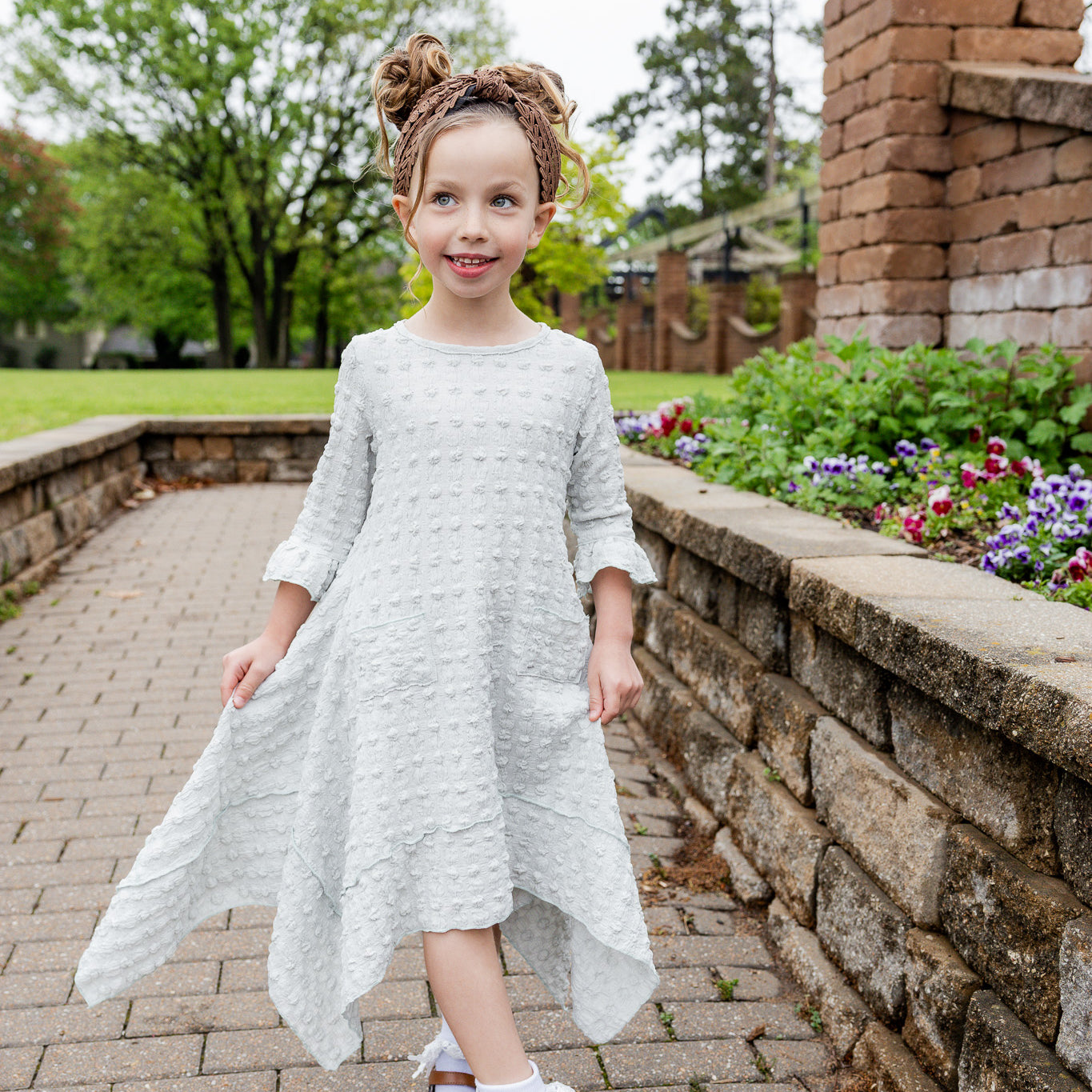 Girls Daphne Dress in textured fabric – front view.