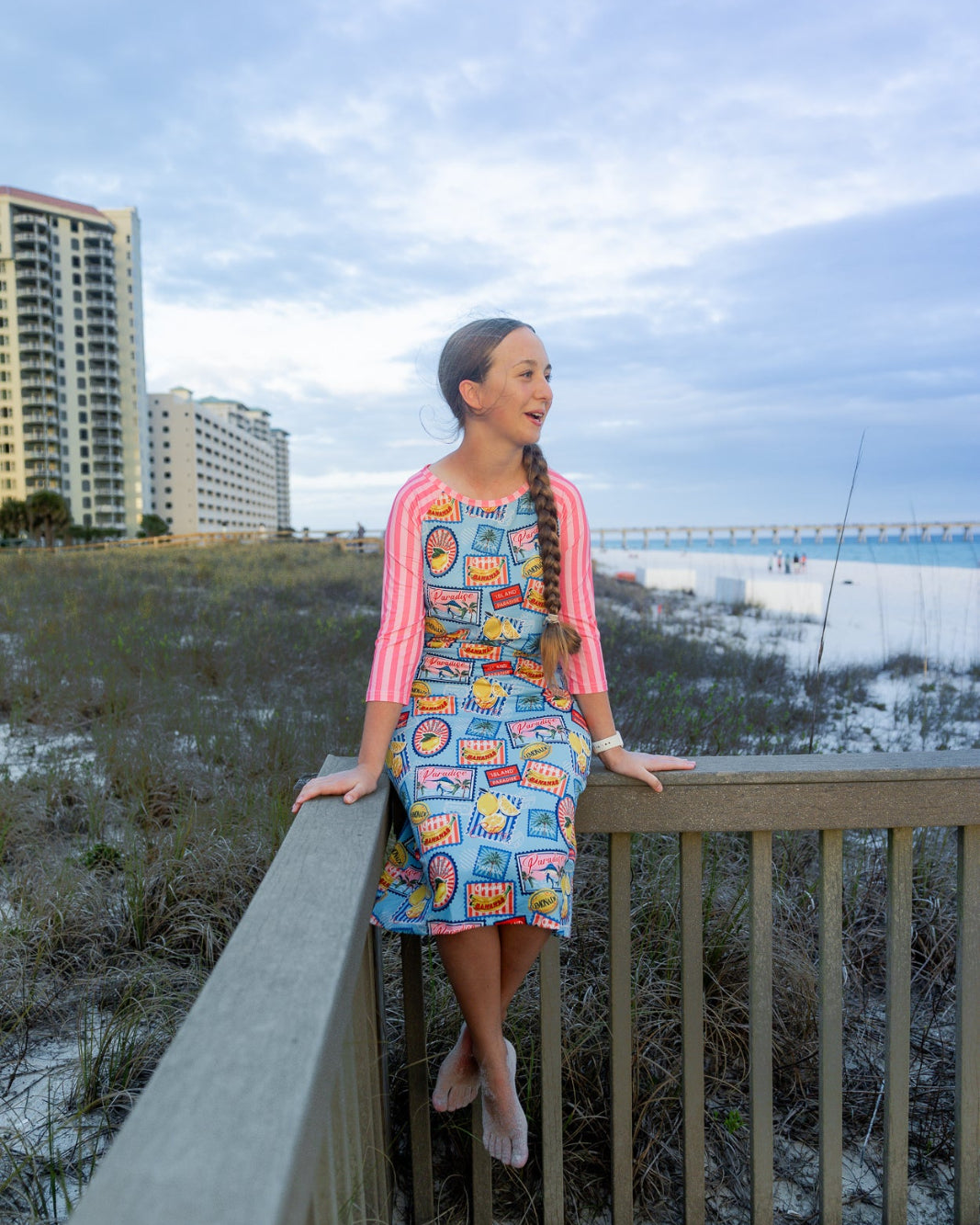 Model wearing Nuggles® Sport Swim Dress in Vacation Postcards