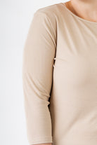 Model wearing the  Nuggles®  Essential 3/4 Tee in ribbed fabric, a modest, fitted top with 3/4 sleeves and a rounded neckline. Shown in a neutral tone, ideal for layering.