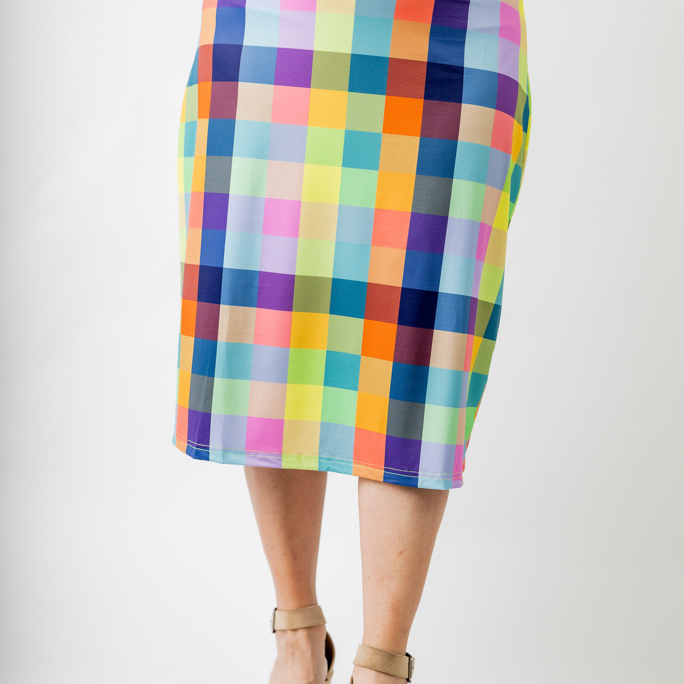 Model wearing Nuggles® Jaxon Plaid 27-inch All Sport Skirt with built-in leggings, featuring vibrant multicolor plaid pattern. Modest athletic skirt for women, designed for activewear and everyday comfort.
