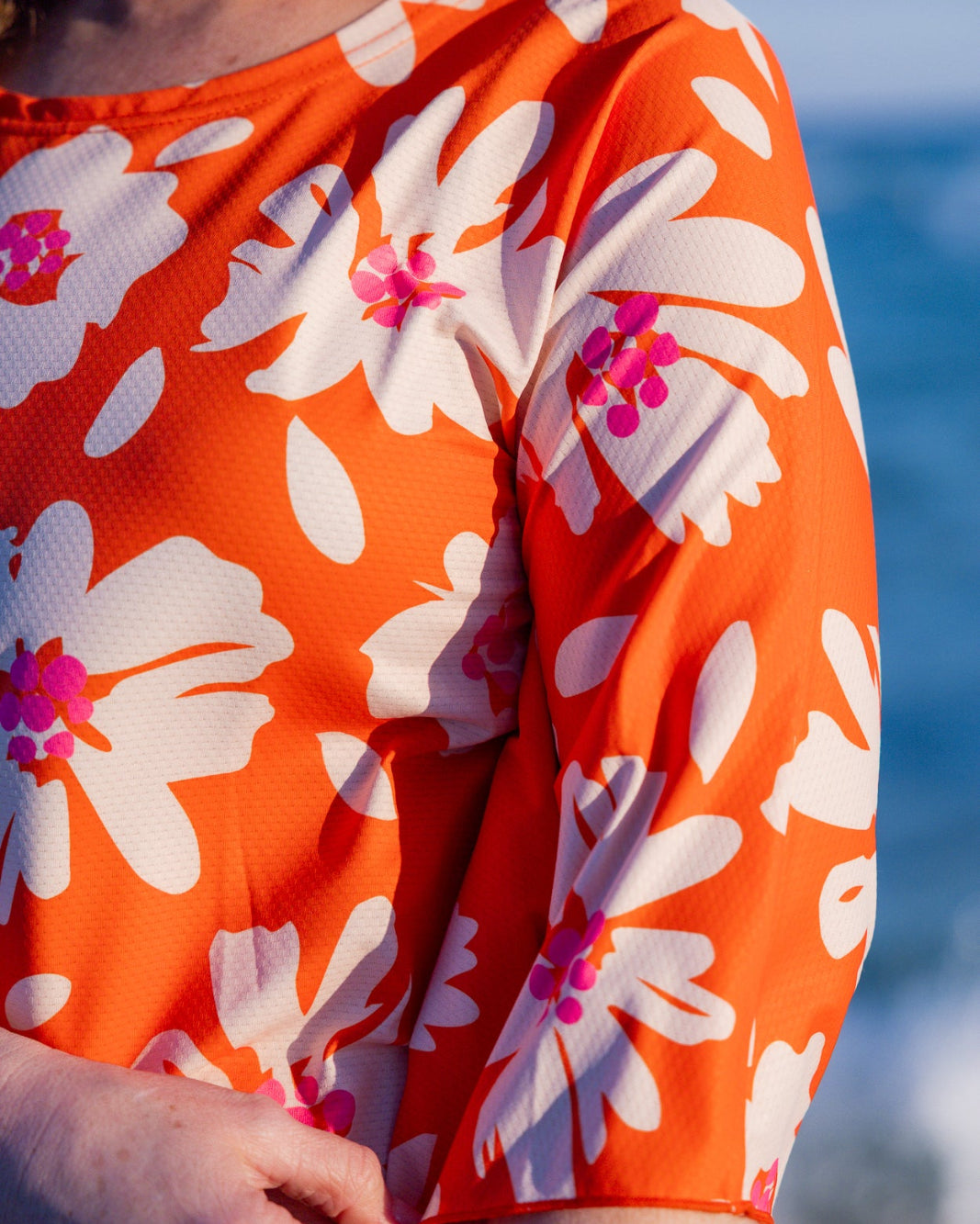 Model wearing Nuggles® Carlie Swim Dress in Sunset Hibiscus