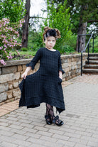 Girls Daphne Dress in textured fabric – front view.