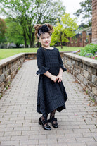 Girls Daphne Dress in textured fabric – front view.