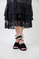 Model wearing 27" lace layering slip with tiered lace hem, designed for modest layering under skirts or dresses.