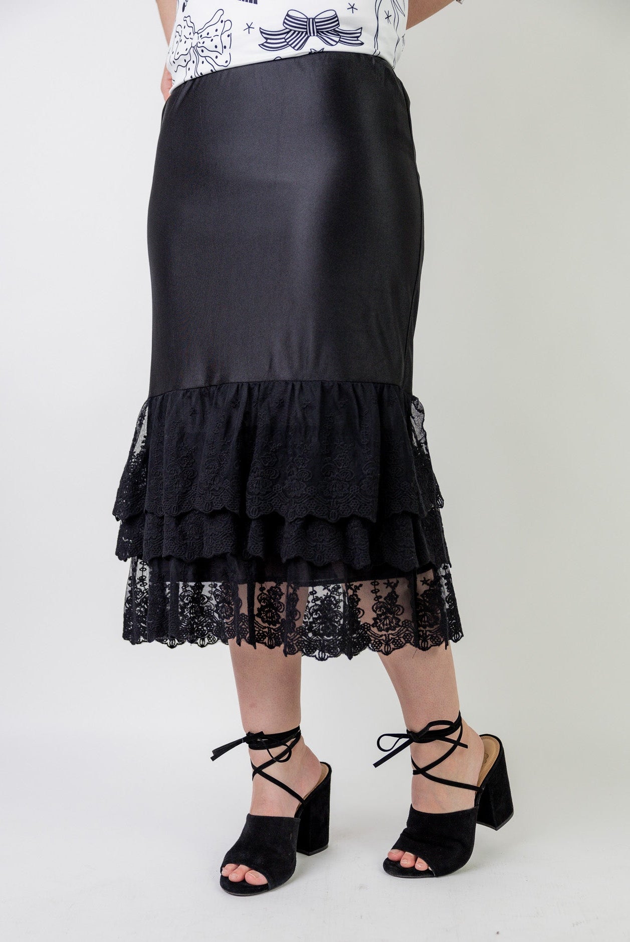 Model wearing 27" lace layering slip with tiered lace hem, designed for modest layering under skirts or dresses.
