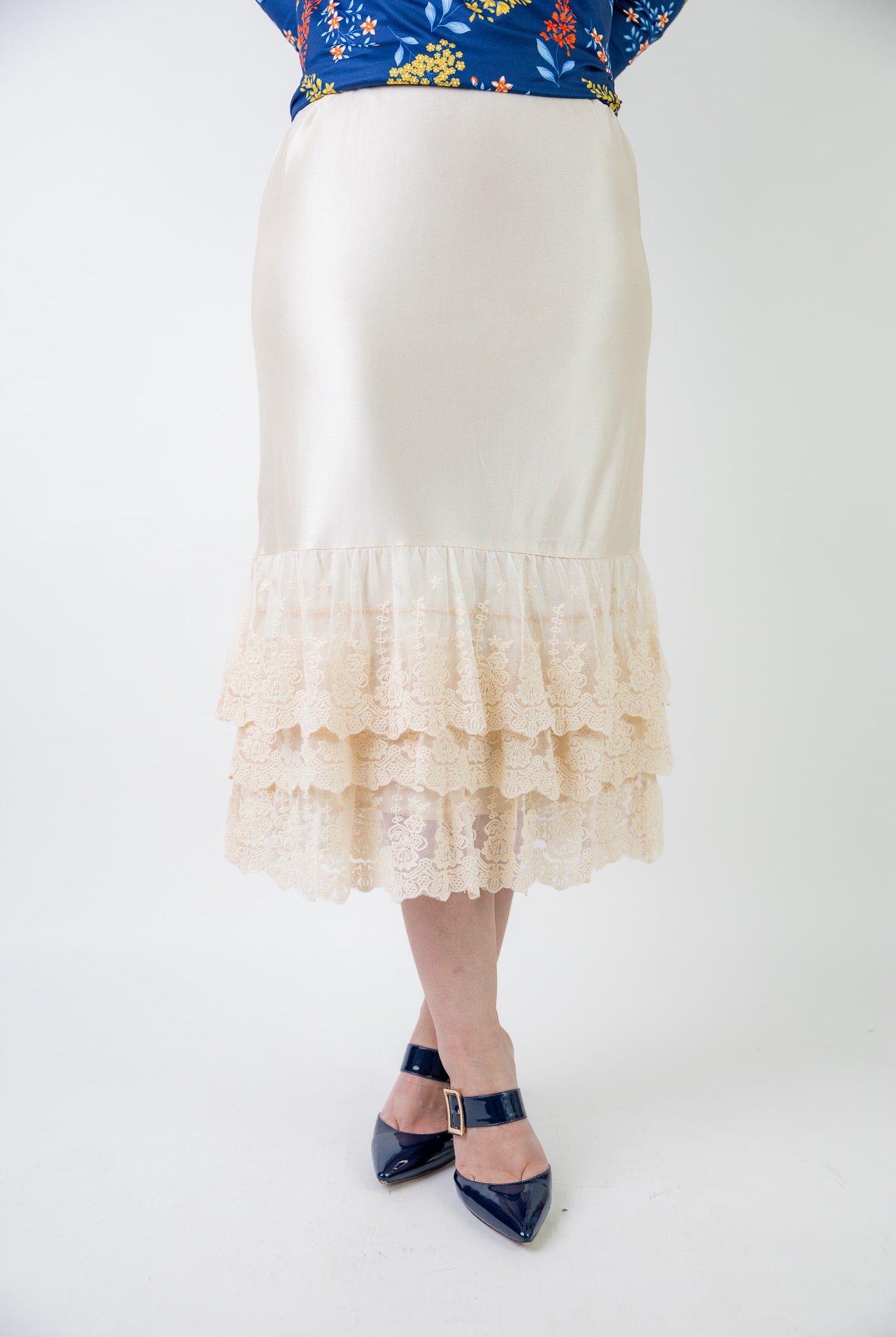 Model wearing 27" lace layering slip with tiered lace hem, designed for modest layering under skirts or dresses.