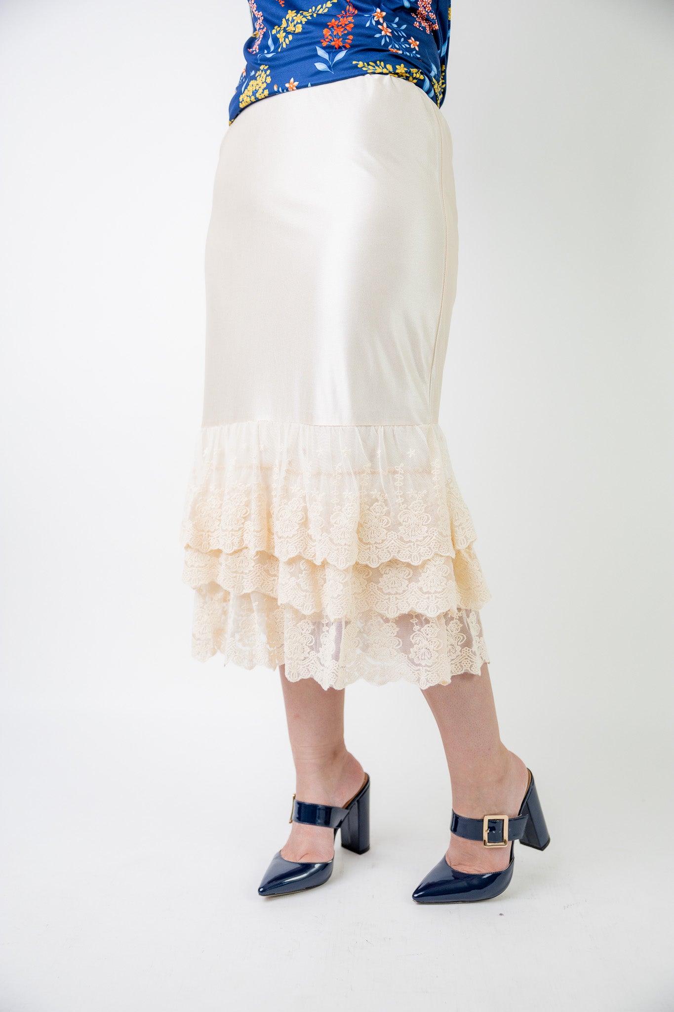 Model wearing 27" lace layering slip with tiered lace hem, designed for modest layering under skirts or dresses.