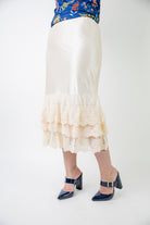 Model wearing 27" lace layering slip with tiered lace hem, designed for modest layering under skirts or dresses.