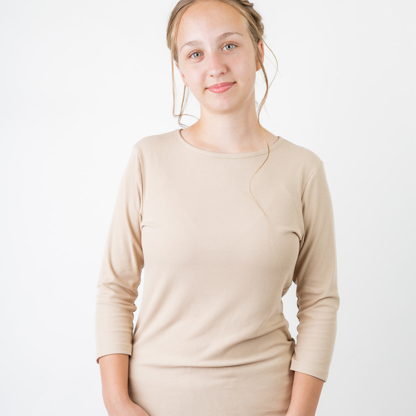 Model wearing the  Nuggles®  Essential 3/4 Tee in ribbed fabric, a modest, fitted top with 3/4 sleeves and a rounded neckline. Shown in a neutral tone, ideal for layering.