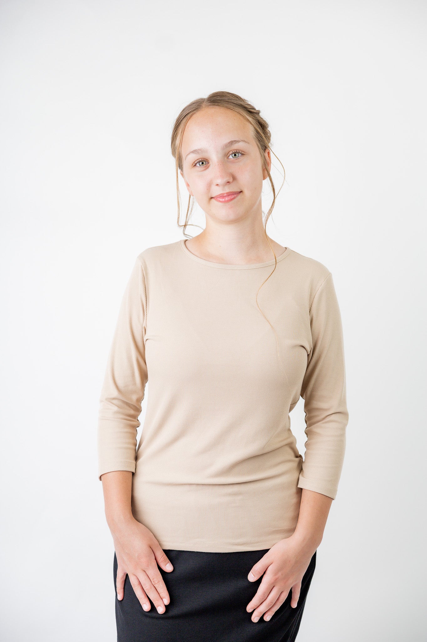 Model wearing the  Nuggles®  Essential 3/4 Tee in ribbed fabric, a modest, fitted top with 3/4 sleeves and a rounded neckline. Shown in a neutral tone, ideal for layering.