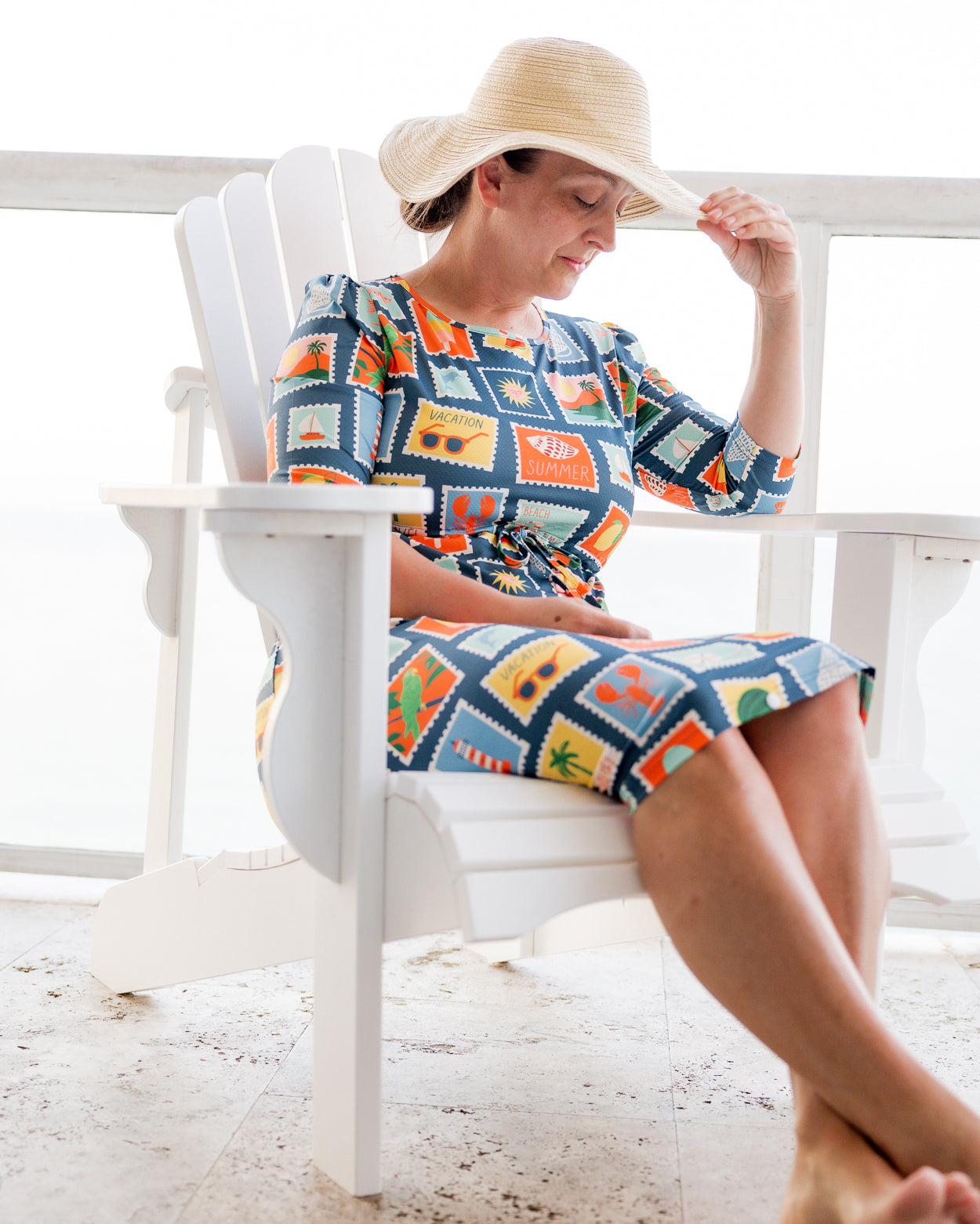 Model wearing Nuggles® Nola Sport Swim Dress in Retro Postcards