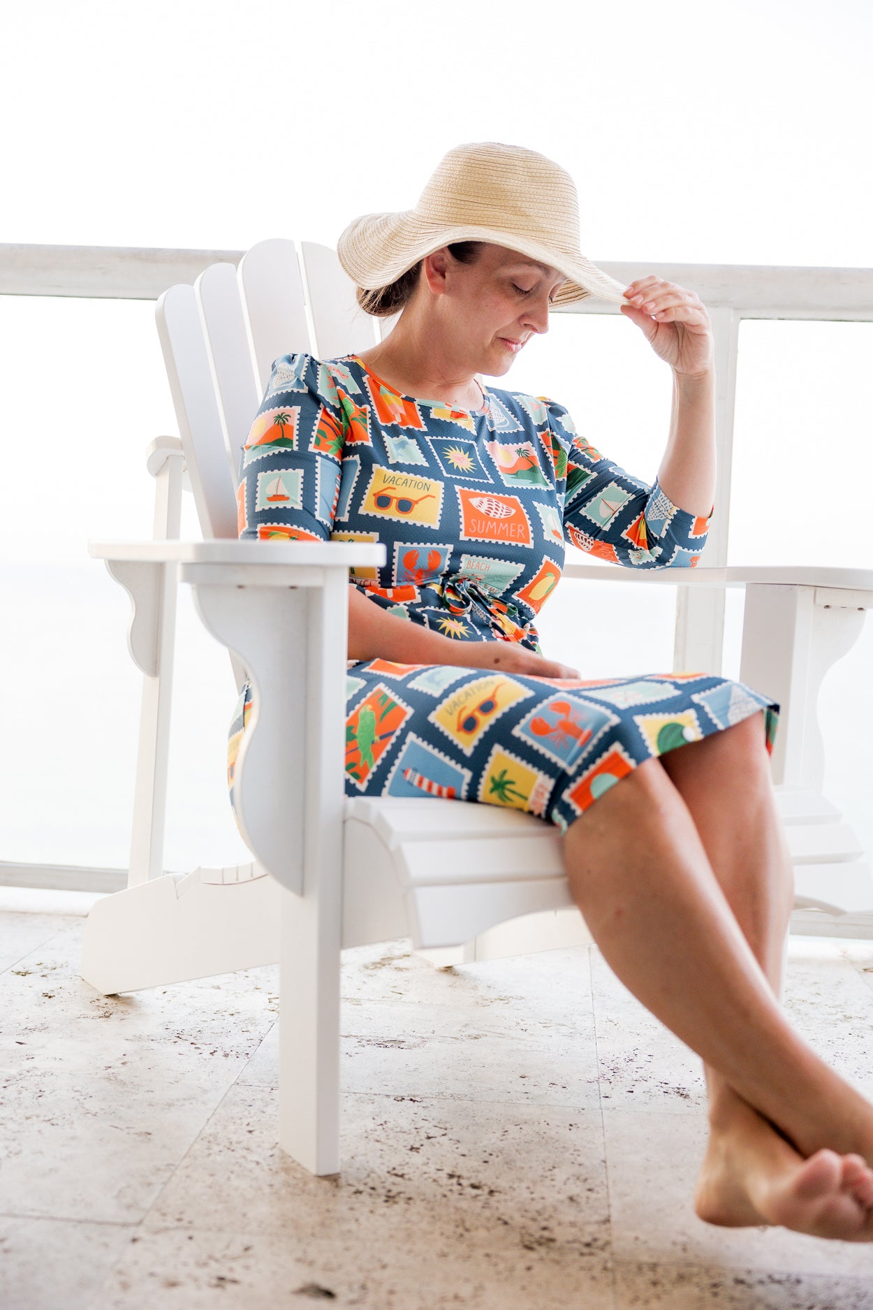 Model wearing Nuggles® Nola Sport Swim Dress in Retro Postcards
