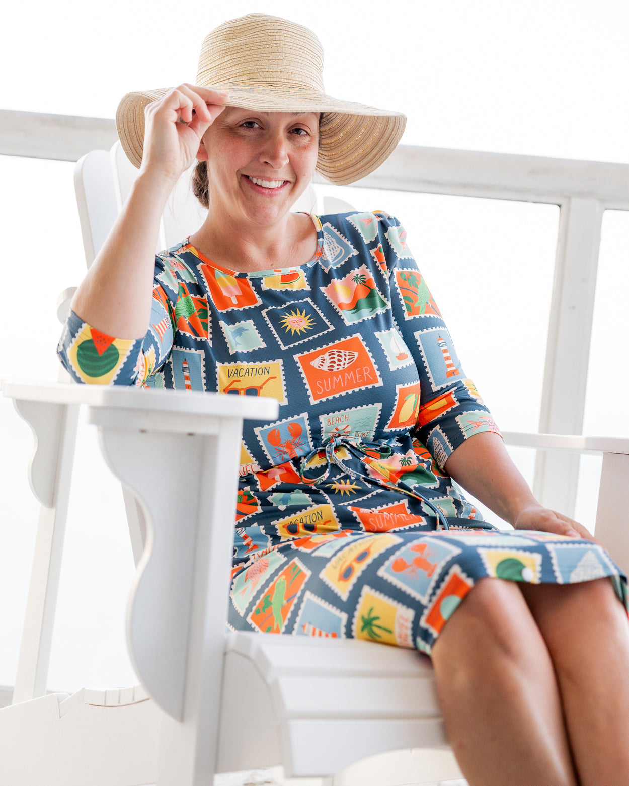 Model wearing Nuggles® Nola Sport Swim Dress in Retro Postcards