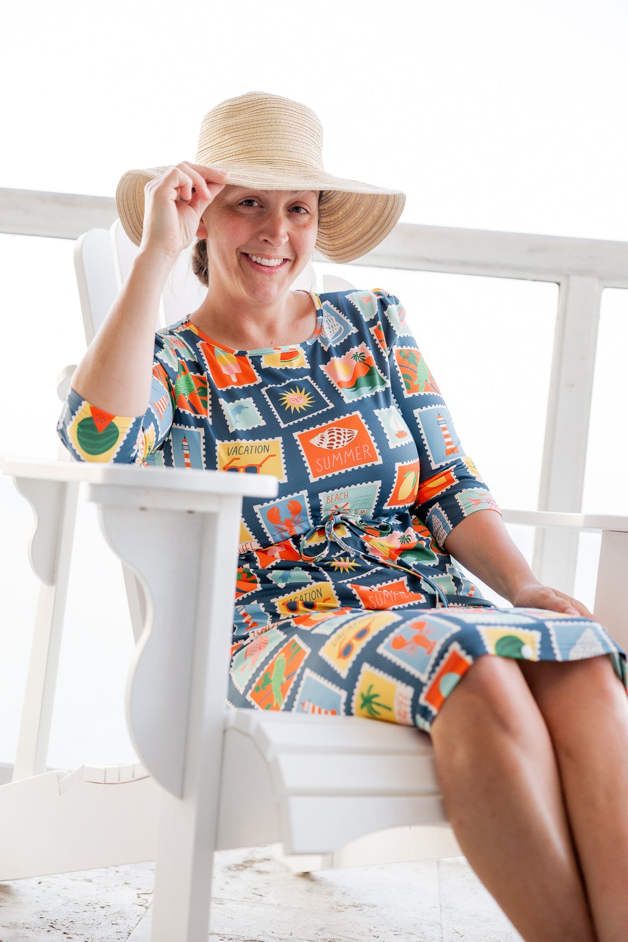 Model wearing Nuggles® Nola Sport Swim Dress in Retro Postcards