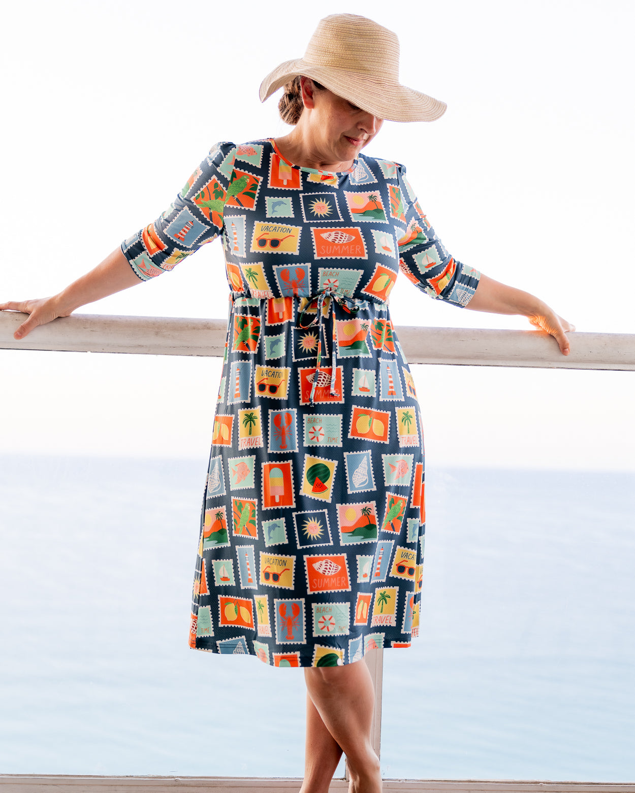 Model wearing Nuggles® Nola Sport Swim Dress in Retro Postcards