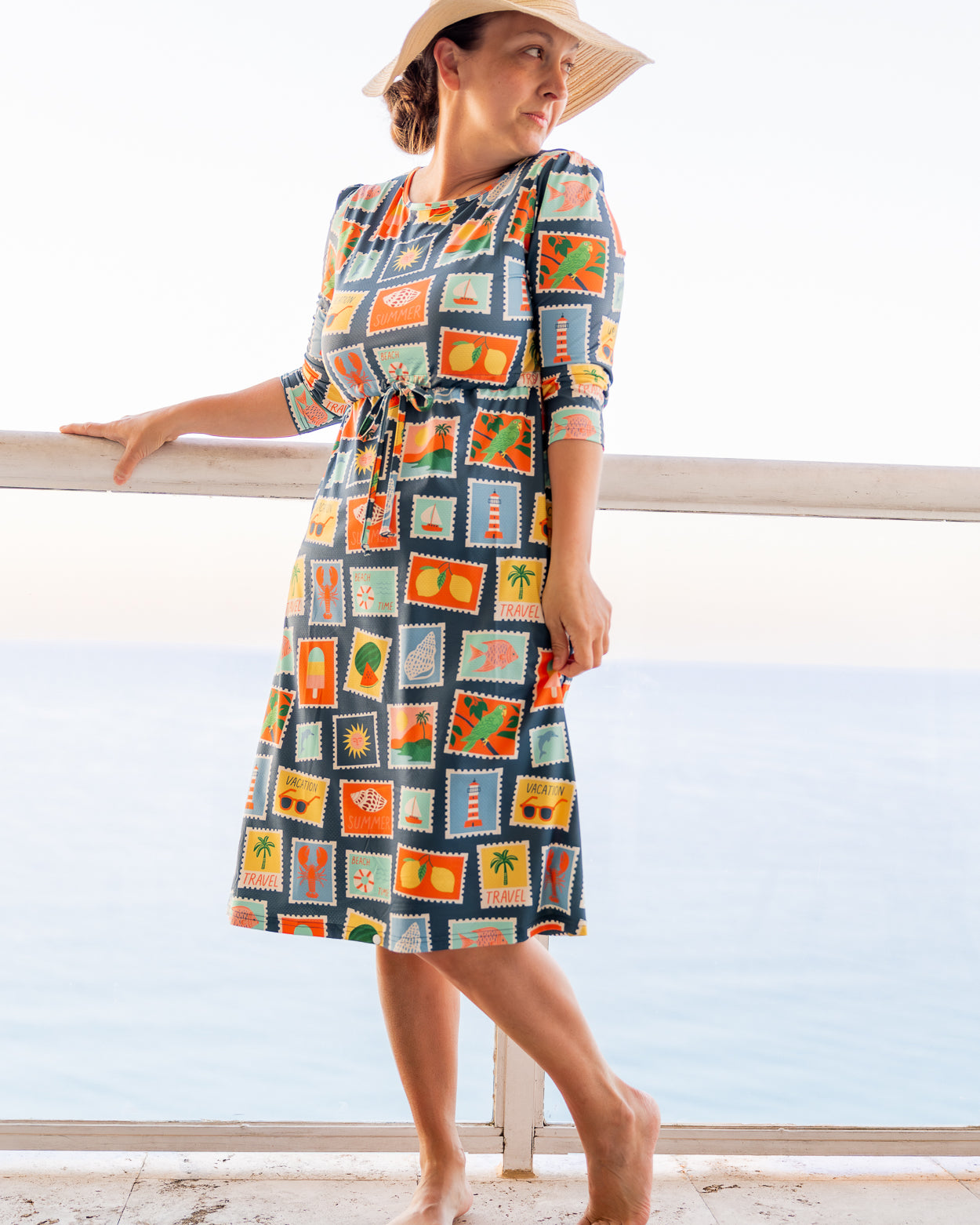 Model wearing Nuggles® Nola Sport Swim Dress in Retro Postcards