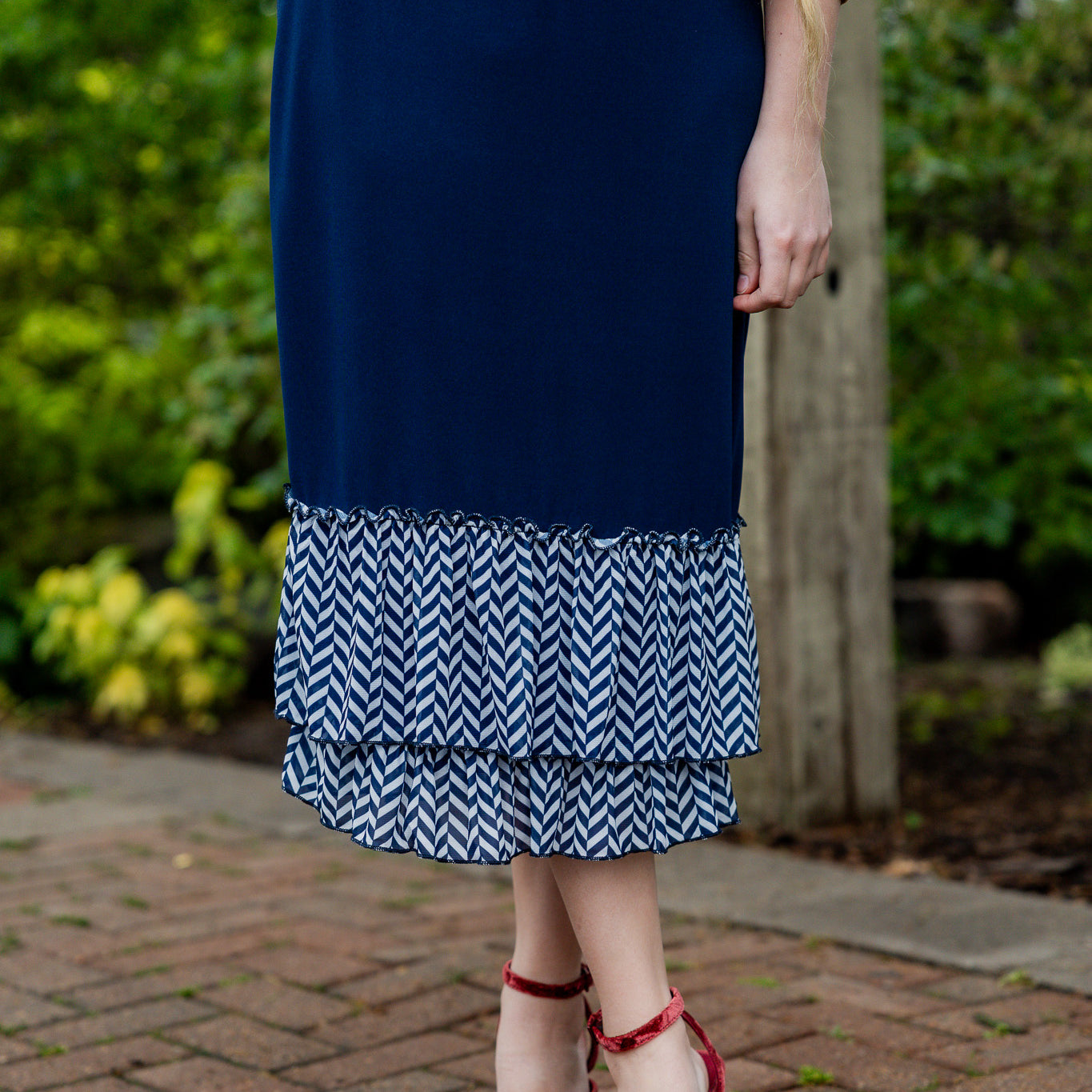 Navy 27" slip skirt with double ruffle hem in white and navy chevron pattern, styled with a beige top.