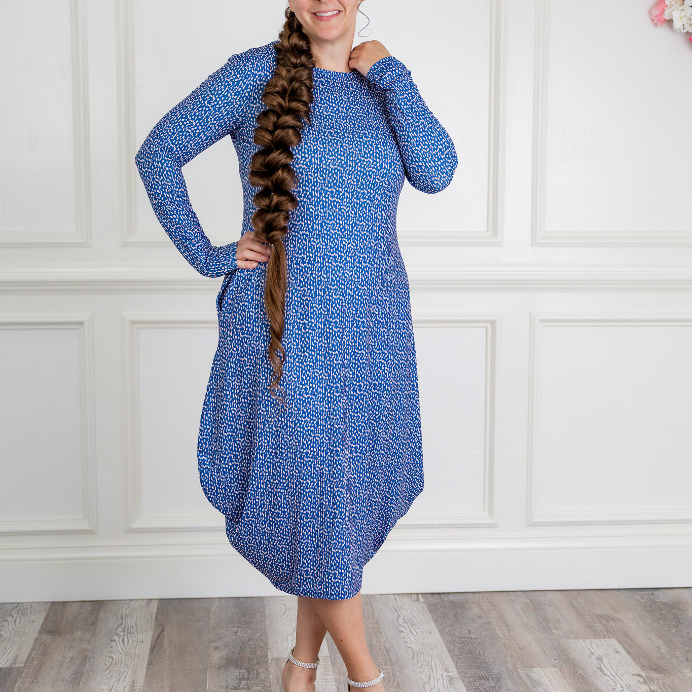 Woman modeling a Nuggles blue pattern midi dress made from soft, stretchy knit fabric, featuring long sleeves and side pockets.