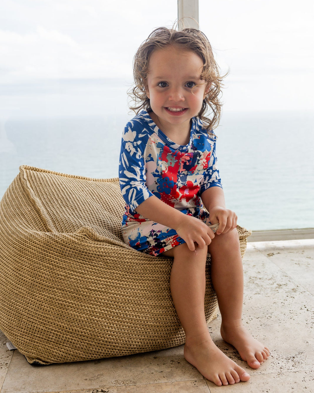 Model wearing Nuggles® Girls' Sport Swim Dress in Firecracker Garden