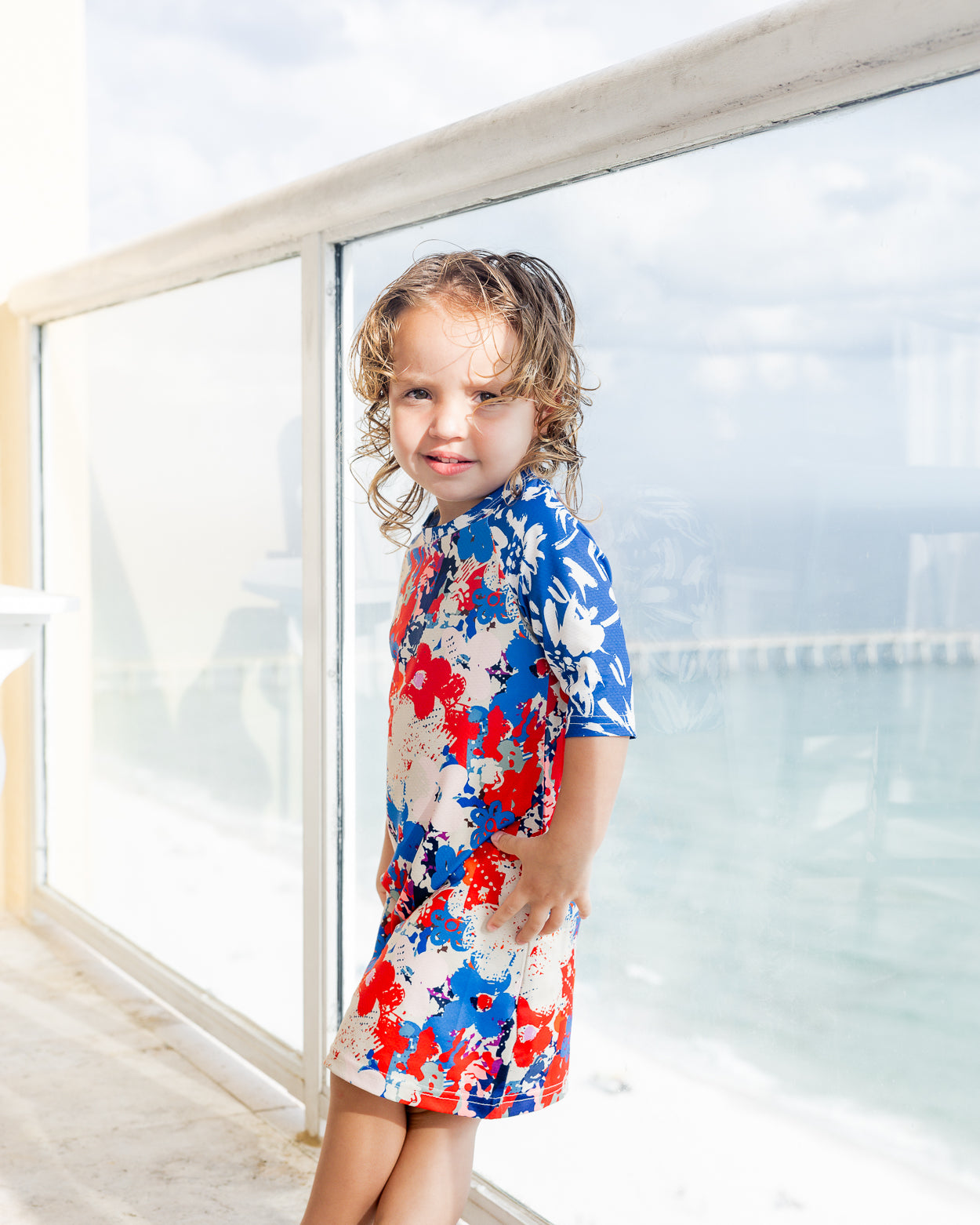 Model wearing Nuggles® Girls' Sport Swim Dress in Firecracker Garden