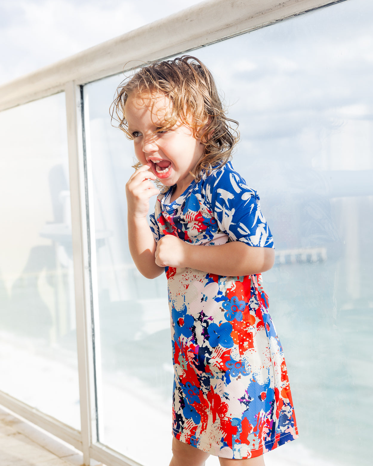 Model wearing Nuggles® Girls' Sport Swim Dress in Firecracker Garden