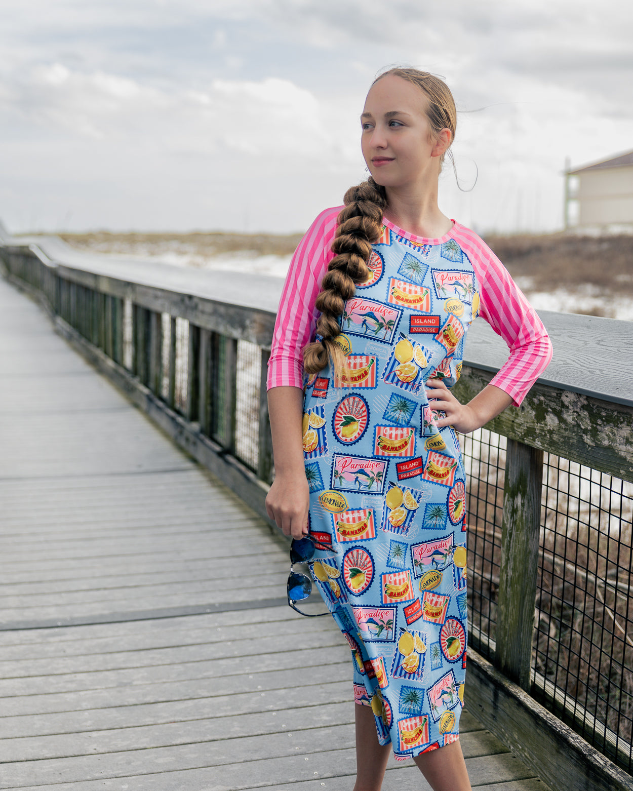 Model wearing Nuggles® Sport Swim Dress in Vacation Postcards