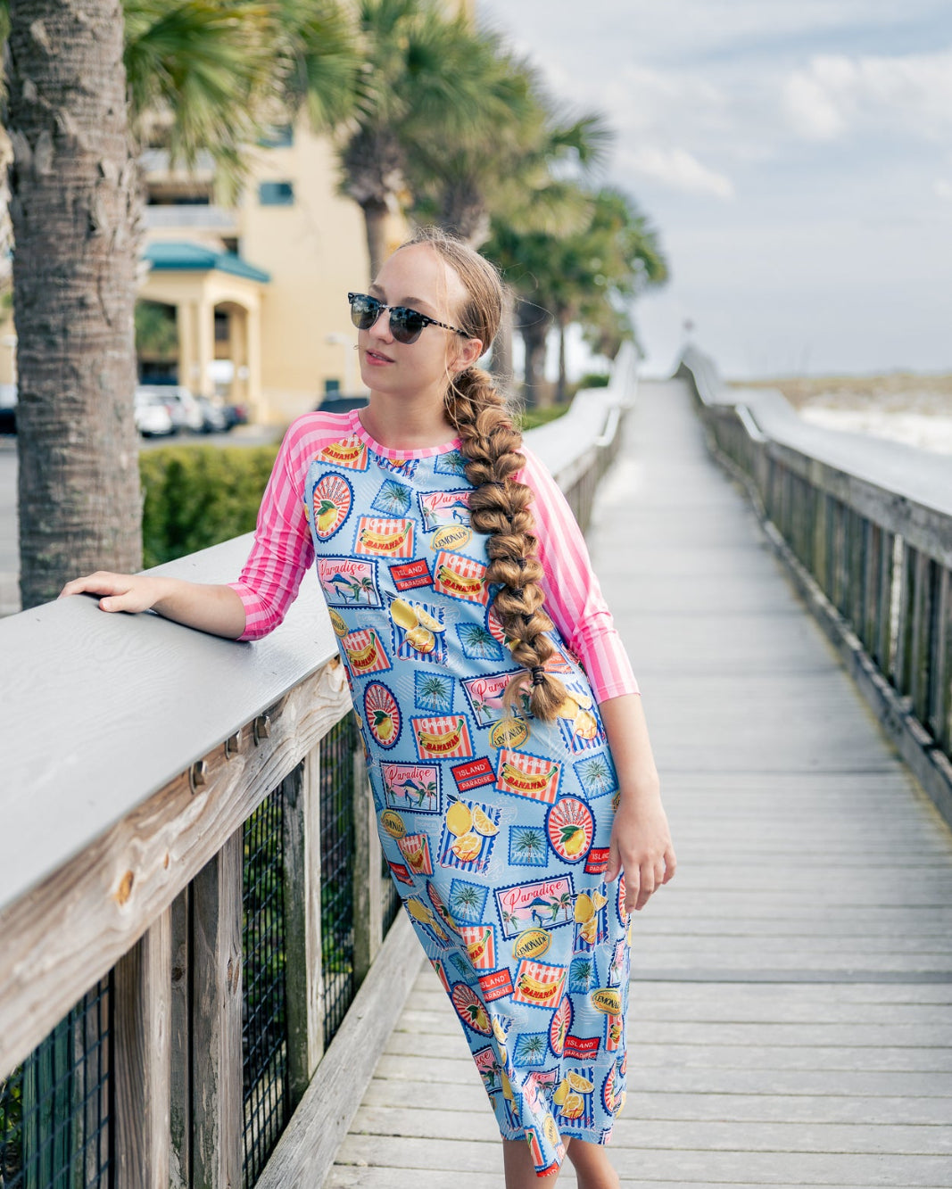 Model wearing Nuggles® Sport Swim Dress in Vacation Postcards