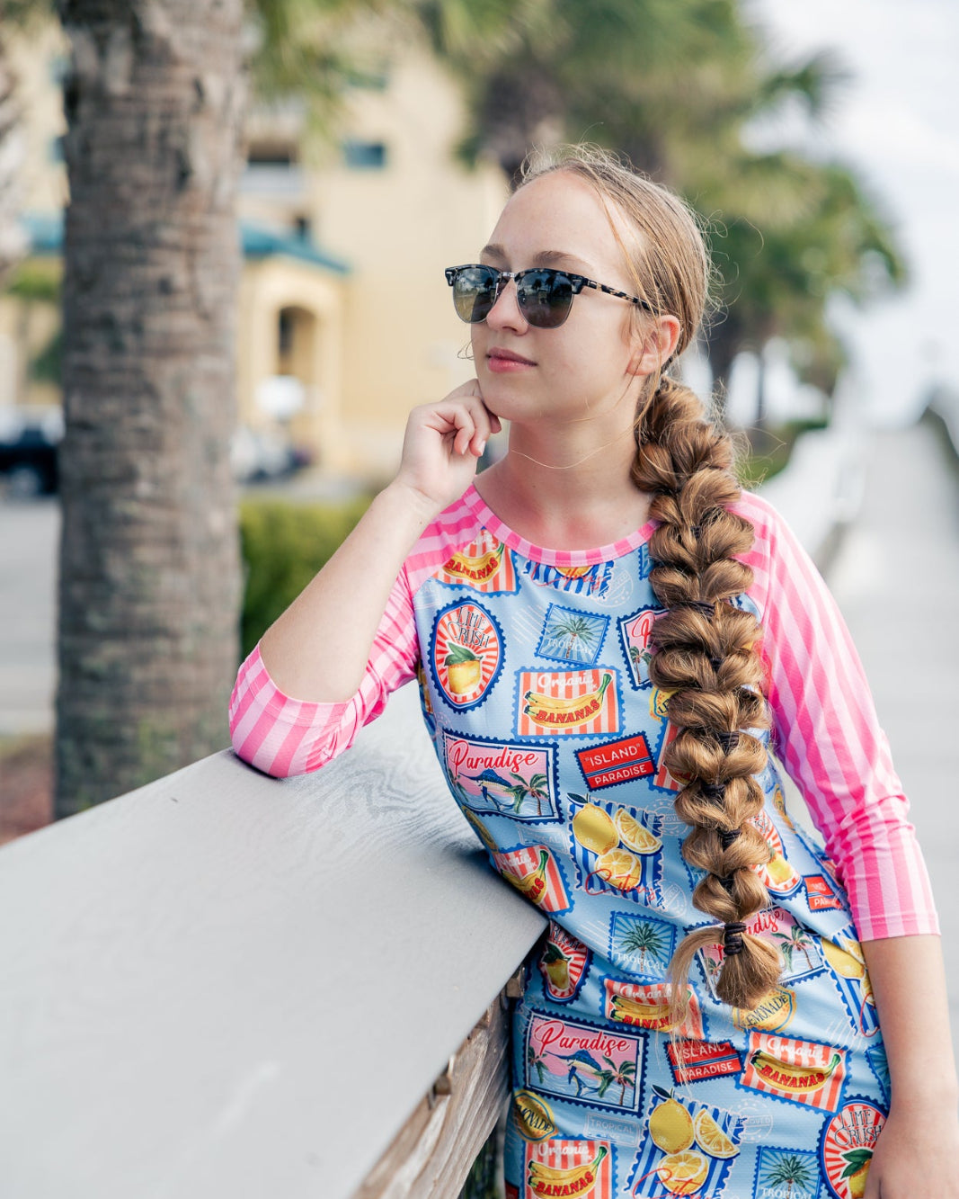 Model wearing Nuggles® Sport Swim Dress in Vacation Postcards