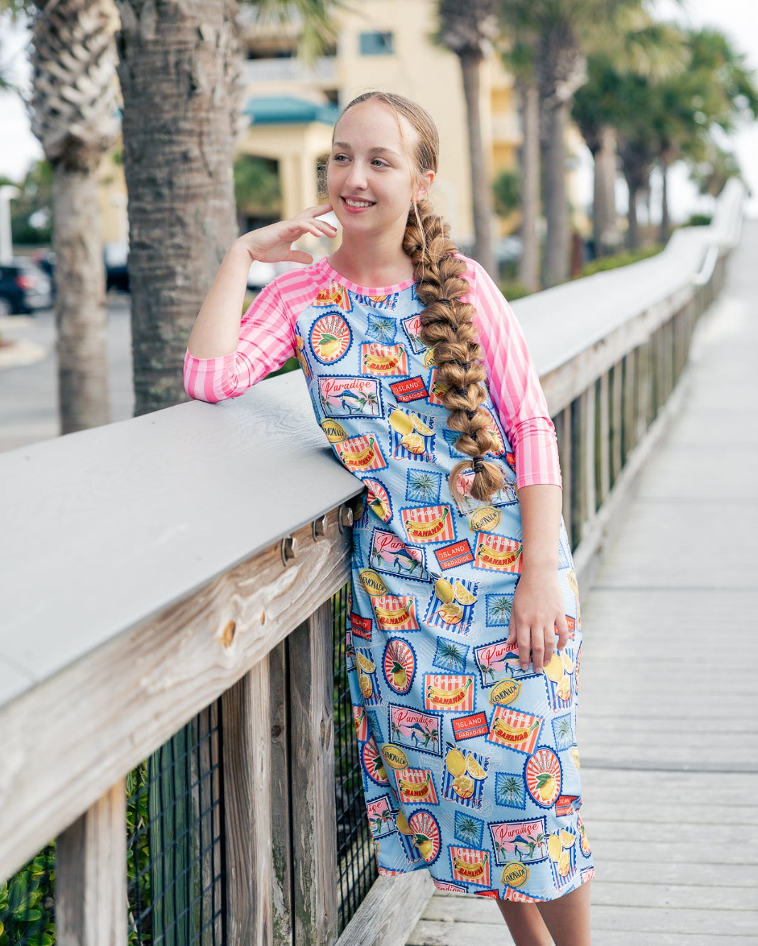 Model wearing Nuggles® Sport Swim Dress in Vacation Postcards