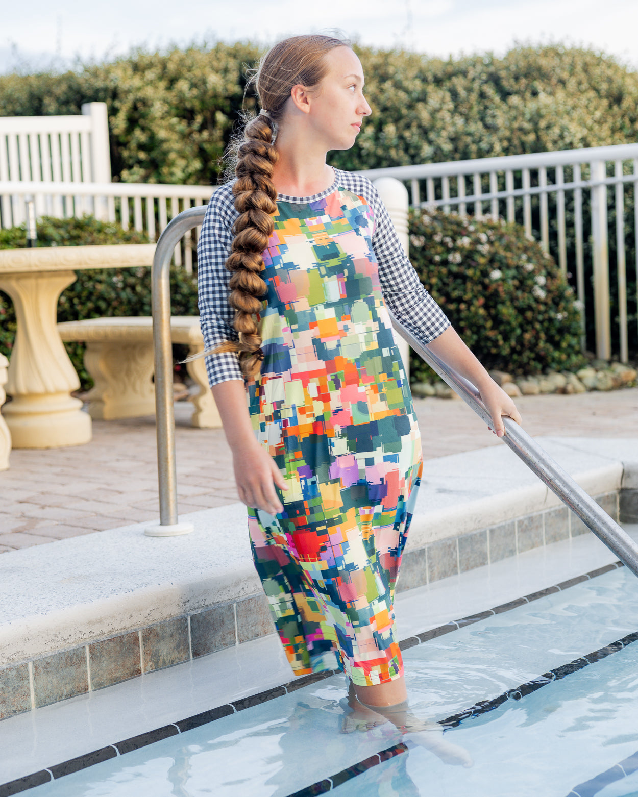 Model wearing Nuggles® Sport Swim Dress in Painted Patchwork