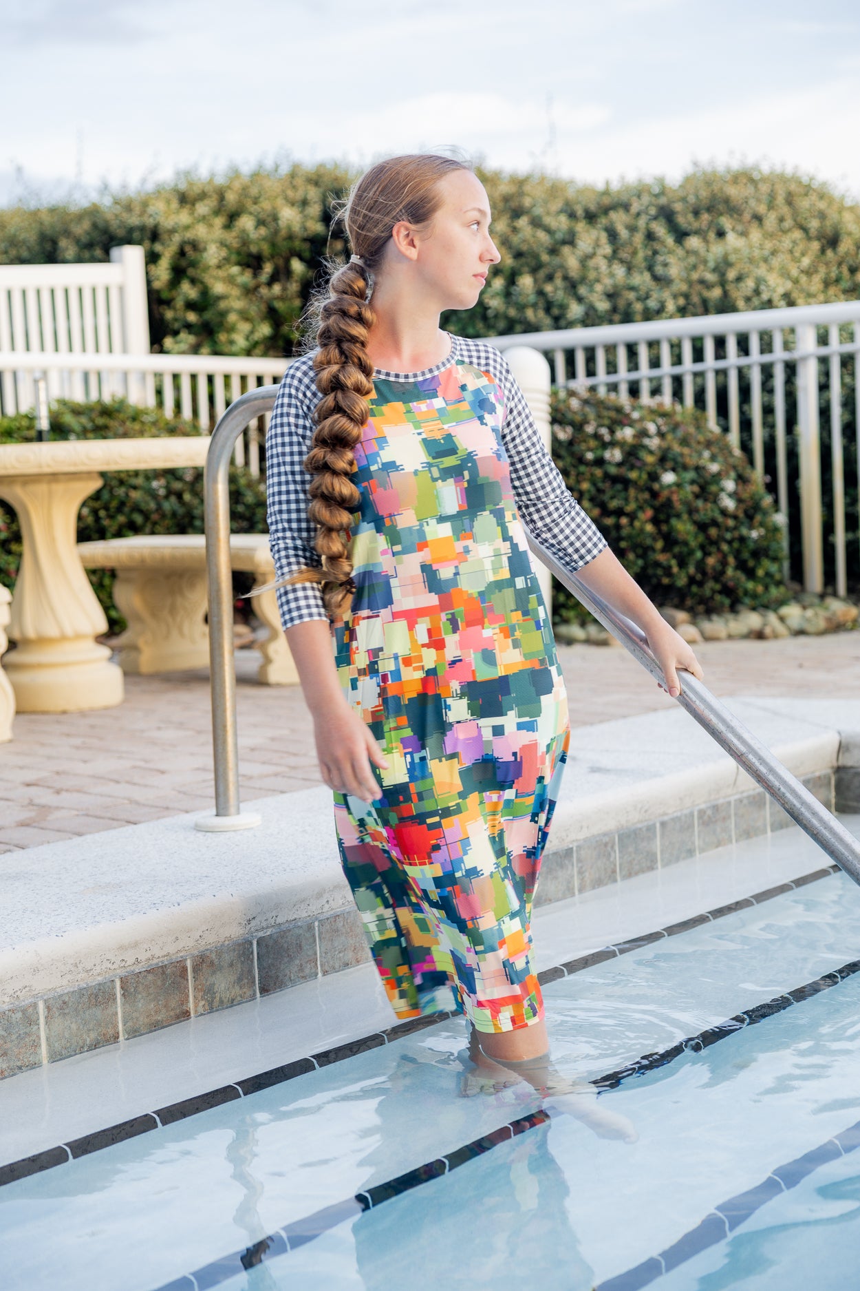 Model wearing Nuggles® Sport Swim Dress in Painted Patchwork