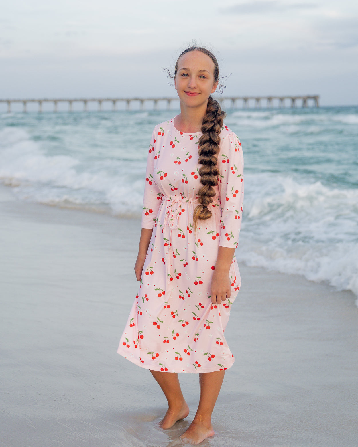 Model wearing Nuggles® Nola Sport Swim Dress in Cherry Soda Shop